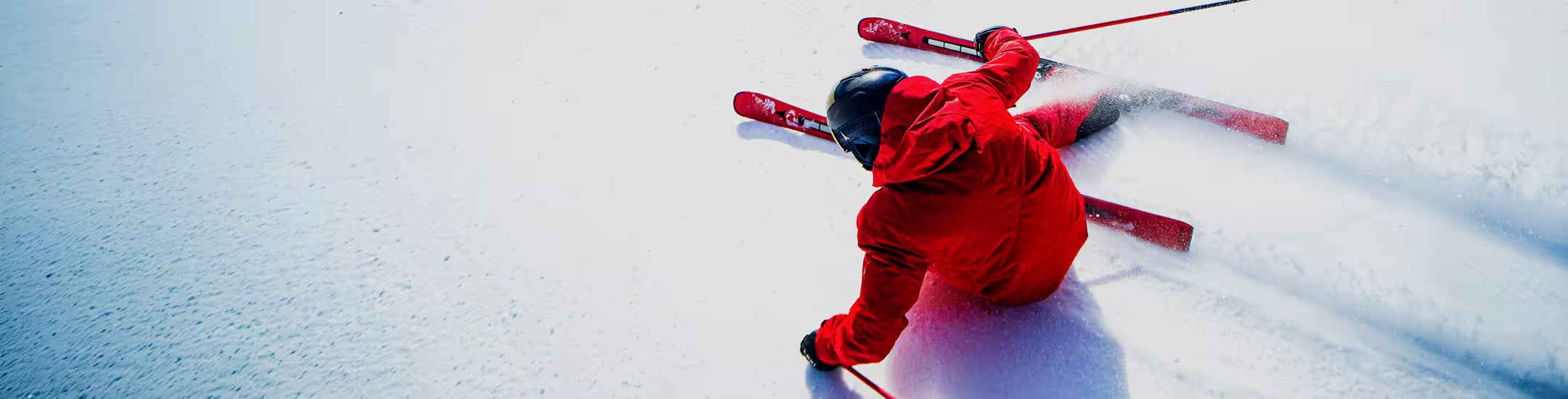 Person skiing in red outfit on a snowy slope