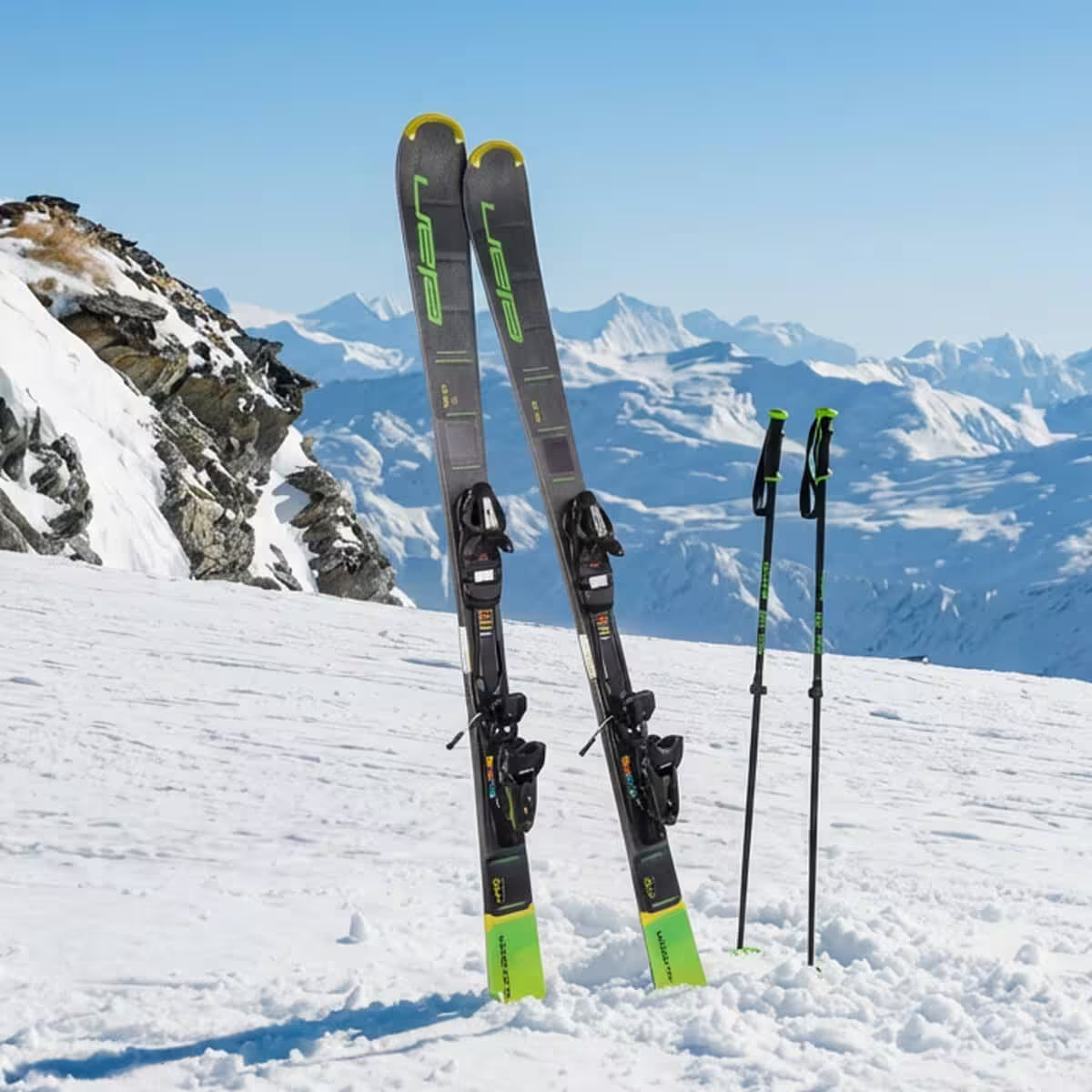 Ski equipment on a snowy mountain with a clear blue sky