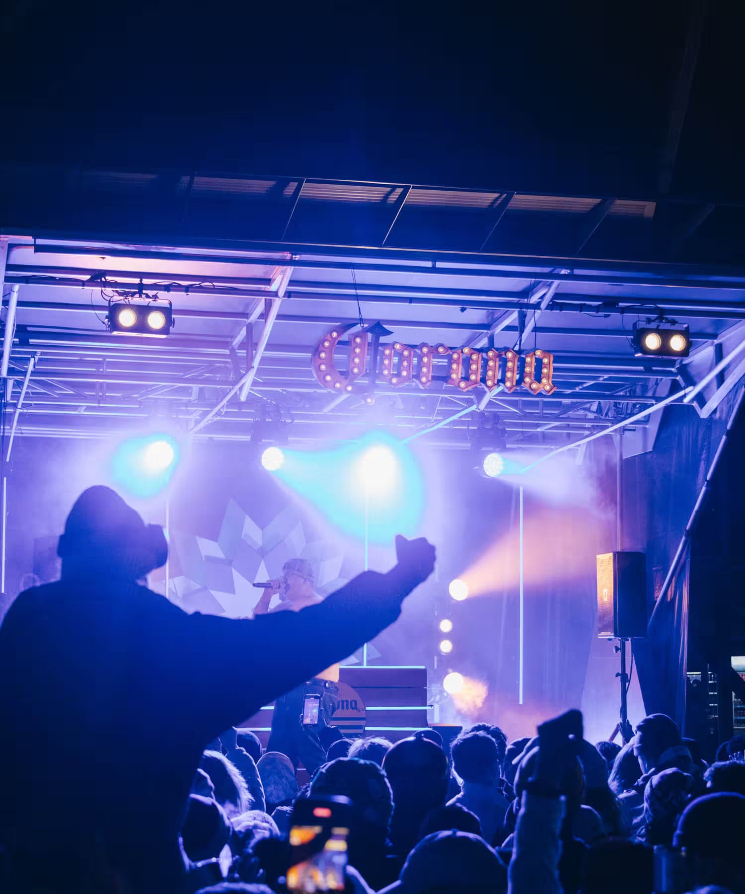 Person at a concert with 'Corona' branding in the background