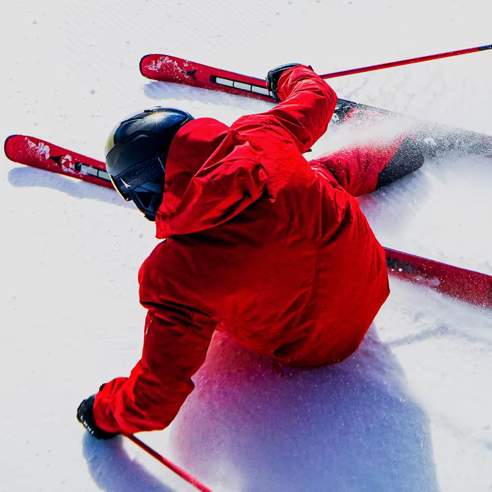 Person skiing in red jacket and pants on a snowy slope